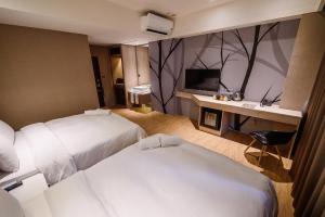 礁溪鄉的住宿－福岡6號溫泉飯店，酒店客房配有两张床和一张书桌