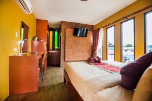 a bedroom with a bed and a sink and a television at Pongphen Guesthouse - SHA Plus Certified in Kanchanaburi