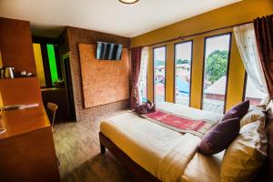 北碧Pongphen Guesthouse - SHA Plus Certified的客房设有床和大窗户。
