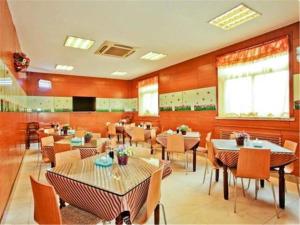 a restaurant with tables and chairs in a room at Jinjiang Inn Select Taiyuan Changfeng Street in Taiyuan