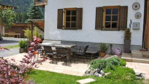 eine Terrasse mit einem Tisch und Stühlen vor einem Haus in der Unterkunft Trudis Hoamat in Bach