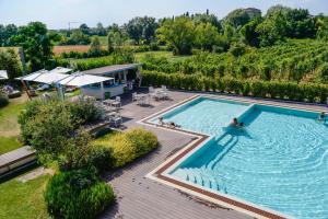 a pool with a pool table and chairs in it at The Ziba Hotel & Spa in Peschiera del Garda