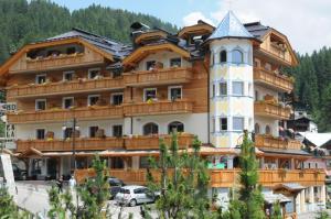 un grande edificio con una torre sopra di Boutique Hotel Diana a Madonna di Campiglio