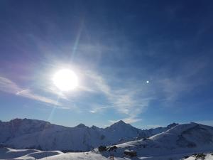 um sol no céu sobre uma montanha coberta de neve em Hotel Camona & Apart Walserhof em Samnaun