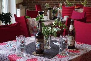 a table with two bottles and glasses on it at Gästehaus am Steinwald in Friedenfels
