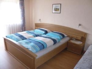 een bed met blauwe en witte kussens erop bij Gastehaus Helga in Bodenmais +4 foto's