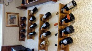 a bunch of wine bottles hanging on a wall at Locanda Da Tullio in Capovalle