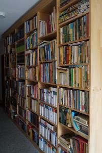 une rangée d'étagères remplies de livres dans l'établissement Gästehaus am Steinwald, à Friedenfels