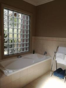 uma grande banheira na casa de banho com uma janela em Conach House em Cambridge