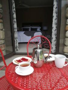 un tavolo rosso con bollitore per il tè e tazze sopra di Conach House a Cambridge