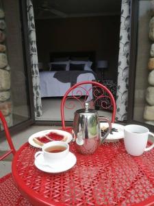 a red table with a tea kettle and cups on it at Conach House in Cambridge +13 photos