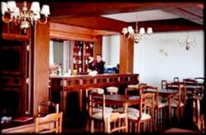 a dining room with a bar and tables and chairs at Hotel Amsterdam in Mar del Plata