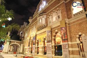 a large brick building with a clock on top at Citin Hotel Masjid Jamek by Compass Hospitality in Kuala Lumpur