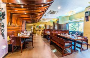 卜山小丘酒店的铺有木地板、桌椅的餐厅