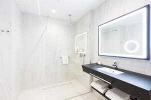 a white bathroom with a sink and a mirror at Grand Ascot Hotel in Krakow +65 photos