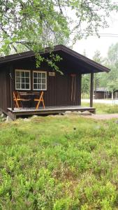 a small cabin with a porch and a picnic table at Sæteråsen Hytter & Camping Trysil in Trysil