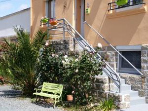 a green bench in front of a house with flowers at Ellias in Pont-lʼAbbé