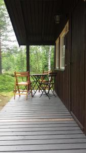 a porch with two picnic tables on a house at Sæteråsen Hytter & Camping Trysil in Trysil