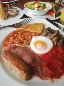 - un plateau de petit-déjeuner composé d'œufs, de saucisses, de haricots verts et de pain grillé dans l'établissement Garrison Hotel, à Sheffield