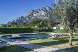 a swimming pool with a mountain in the background at Verdepiano Bed & Camping in Riva del Garda