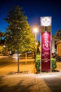 an Hotel في Selm: شجرة و لافتة على شارع في الليل