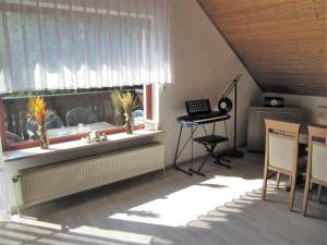 een woonkamer met een raam met een tafel en een bureau bij Ferienwohnung Wohlfeld in Habighorst