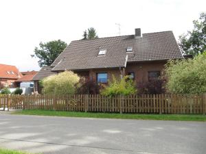 una casa con una valla de madera delante de ella en Ferienwohnung Wohlfeld, en Habighorst