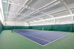 a tennis court in a building with a tennis racket at Hotel Tayozhny in Moscow
