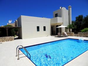 a swimming pool in front of a villa at Villa Athina in Asprouliánoi