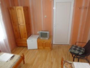 a small room with a tv on a wooden floor at Prometei in Burgas