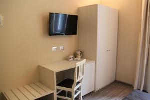 Habitación con escritorio y TV en la pared. en Il Viale b&b, en Pontedera