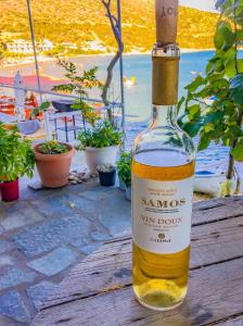 butelka wina na drewnianym stole w obiekcie Island Apartments w mieście Psili Ammos