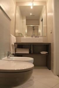 a bathroom with a sink and a toilet and a mirror at Il Viale b&b in Pontedera