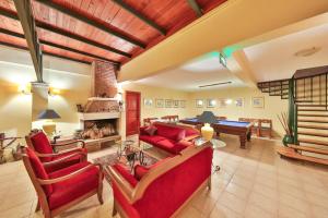 a living room with red furniture and a pool table at Diva Residence Allsuite Hotel in Kaş