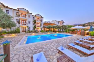 a villa with a swimming pool and lounge chairs at Diva Residence Allsuite Hotel in Kas
