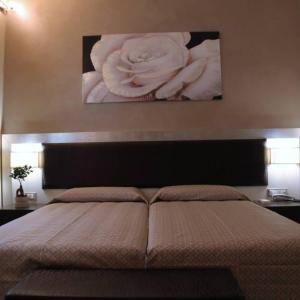 蓬泰代拉的住宿－Il Viale b&b，卧室配有一张大床,墙上挂着一幅画