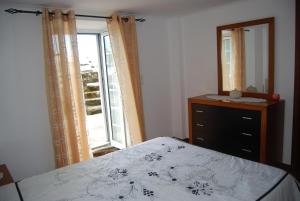 een slaapkamer met een bed, een dressoir en een raam bij Casa do Terreiro in Caminho de Cima