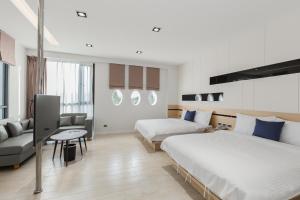 ein Hotelzimmer mit 2 Betten und einem Sofa in der Unterkunft Ai Mei Homestay in Huxi