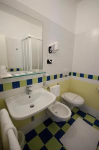 ein Badezimmer mit einem Waschbecken, einem WC und einem Spiegel in der Unterkunft Hotel Ideal in Cupra Marittima