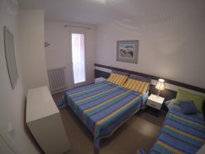 a small bedroom with a bed and a couch at Residence Orate - Agenzia Cocal in Caorle