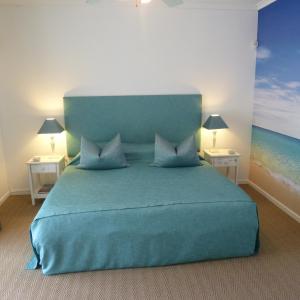 a bedroom with a blue bed with two night stands at Church Hills Boutique Accommodation in Riebeek-Wes