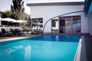a swimming pool in front of a house at Vlnka Apartments in Piešťany