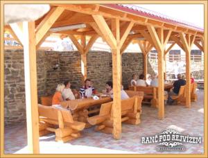 a group of people sitting under a wooden pavilion at Ranc pod Rejvizem in Zlaté Hory