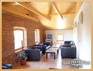 a living room with couches and a brick wall at Ranc pod Rejvizem in Zlaté Hory