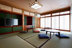 ein Wohnzimmer mit einem TV und einem Tisch in der Unterkunft 宿屋 天空 in Asago