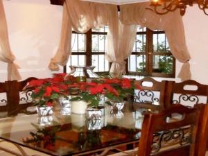 una mesa de comedor con flores rojas en jarrones en Hotel Casa Madeleine B&B & Spa, en Antigua Guatemala