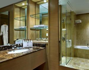 a bathroom with a sink, mirror, and bathtub at Pullman Kuala Lumpur City Centre Hotel & Residences in Kuala Lumpur