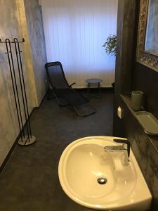 a bathroom with a sink and a chair at Suite Edin in Maintal