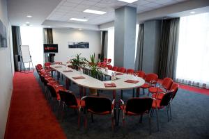 una sala de conferencias con una mesa larga y sillas rojas en Hotel Moskva, en Simferopol