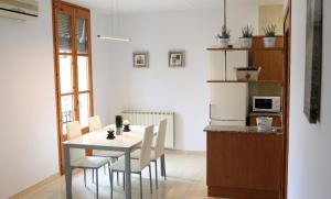 a dining room with a table and chairs and a kitchen at Cal Fasi in Torá de Rulbregos